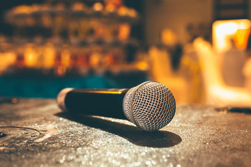 Microphone on the ground and blurred photo of conference hall or seminar room or wedding room background. - obrazy, fototapety, plakaty