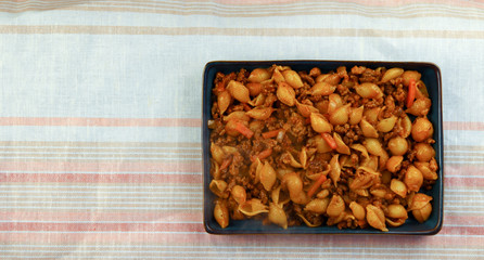 Pasta with minced meat and tomato sauce on blue plate