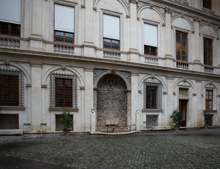 Fototapeta na wymiar Cobbled courtyard and a fountain in the wall
