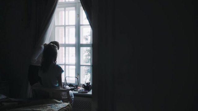 Girl sitting in a chair on a winter day looking out the window