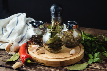 Spices in glass jars on a dark background