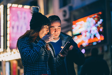 attractive woman and man smiling using smart phone