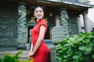 Chinese girl in traditional dress smiling at china temple