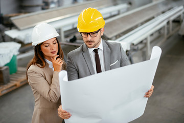 Close up of colleagues in factory. Architects working on project.