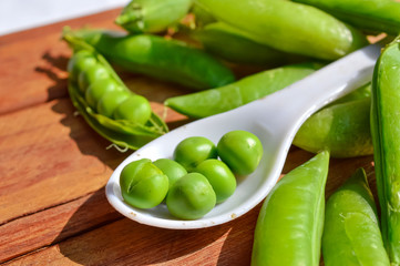 spoon in peas beans,wooden table on peas beans,green peas beans,healthy pea