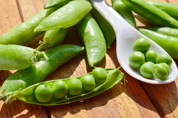 green peas beans on wooden table,peas beans on wood,white spoon in peas bean ,close up view of peas beans