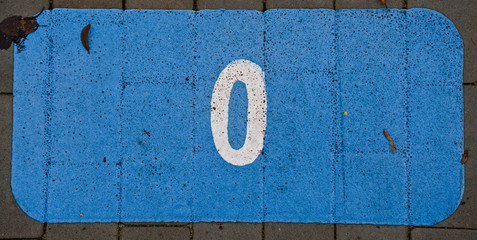 Painted 0 zero on a pavement blue background