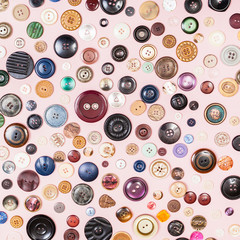 many various buttons on pink background