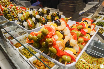 Stuffed green olives on wooden sticks on sale at Mercado San Miguel market in Madrid, Spain