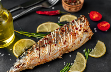 baked mackerel with lemon and spices on a stone background, ready to eat