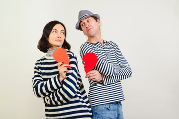 Unhappy valentine day. Young couple holding broken heart. Family quarrels and conflicts