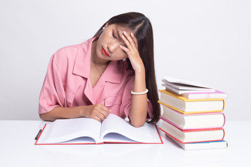 Exhausted Young Asian woman read a book with books on table.