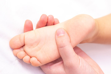 Masseur massaging a small children's foot. Mother is doing massage on her baby foot. Prevention of flat feet, development, muscle tone, dysplasia.