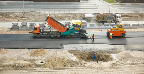 Dump truck unloads asphalt into paver © Miramiska