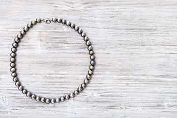 Fototapeta na wymiar top view of natural black pearls necklace on gray