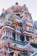 Fototapeta na wymiar Colorful Gopuram Of Various Hindu God Idols On The Top Of Dome Or Crown In South Indian Temple. A Beautiful Art And Architecture