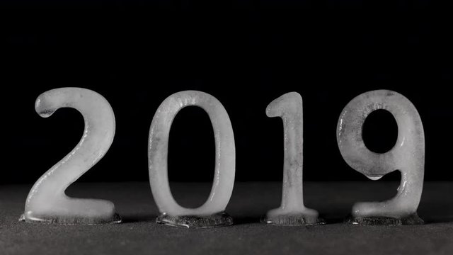 Time lapse of 2019 text written with ice characters melting. Conceptual video of the decade ending and the global warming concerns that raised during this year