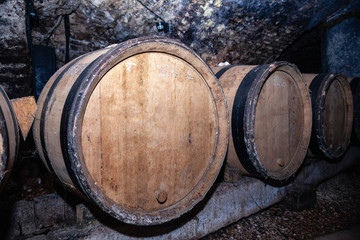 Wooden giant wine oak barrels stacked in rows. Aging, fermentation, store in old wine cellar. Concept sommelier trip, excursion to Bourgogne winery, cask, wine making process, wine lover' travel