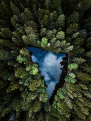 Aerial view of small blue alpine lake in the green pine forest near the Eibsee lake,Germany,Europe.
