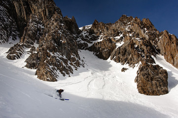 View of snowboarder sliding down the mountain side