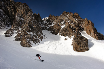 Fototapeta na wymiar View at snowboarder sliding down the mountain side