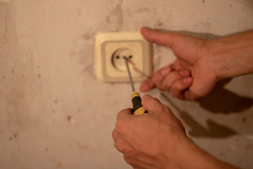 Electrician working at plug socket in a kitchen,horizontal