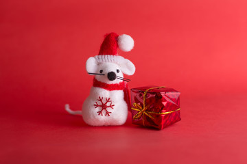 2020 New year of the white metal (silver) rat. Greeting card with symbol of the eastern calendar. Cute toy in Christmas red hat with snowflake on the red background.