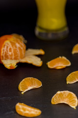 pieces of tangerines on white and glass with tangerine juice