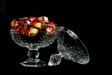 carved glass bonbonniere full of chocolates wrapped in red