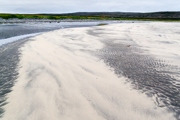 Patterns of black and yellow sand in the tidal zone on the beach of the North Sea