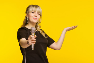 Presentation, public speech, conference, broadcasting, advertising. Cheerful young businesswoman, reporter, TV presenter holding microphone isolated bright yellow background. - obrazy, fototapety, plakaty