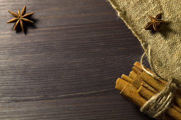 cinnamon sticks and star anise with sackcloth on wooden background with copy spaces top view