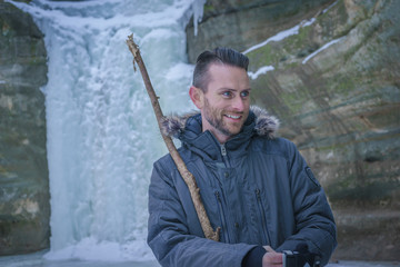 A young attractive man hiking in the winter weather at Starved Rock State Park near Chicago, Illinois, USA.