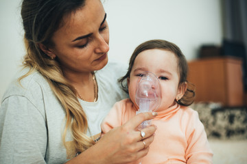 Mom makes inhalation of the child, holding hands