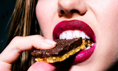 Tasty snack. Dessert for a girl. Female mouth with white teeth close-up. Calories and Carbons....