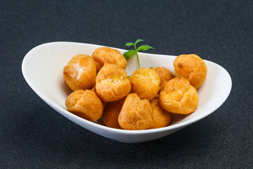 Sweet tasty profiteroles heap in the bowl