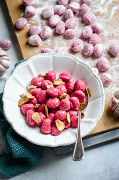 Beetroot gnocchi in a bowl with hazelnuts