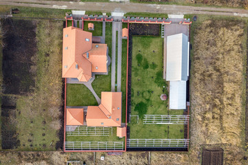 Top down aerial view of a private house with red tiled roof and frame structure prepared for installation of solar panels.