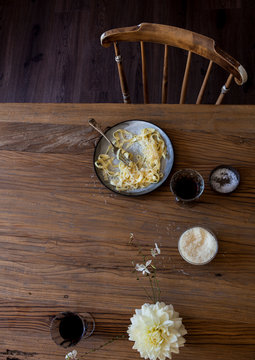 Kitchen table setting of pasta fettuccine food dish with drink shot from above
