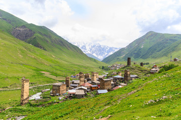 Fototapeta na wymiar View of the Ushguli village at the foot of Mt. Shkhara. Picturesque and gorgeous scene. Rock tower towers and old houses in Ushguli