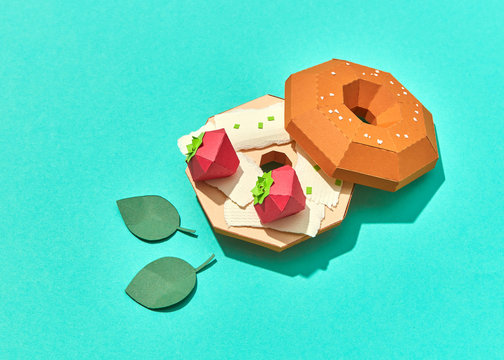 Handmade food origami from paper - cheese burger with strawberry on a turquoise background.
