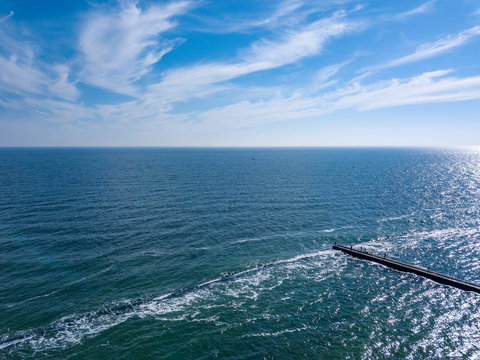 Panoramic view from dron seascape blue surface with stone breakw