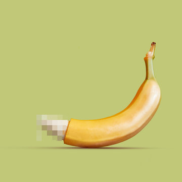 Large banana as a symbol of the penis on a yellow background.