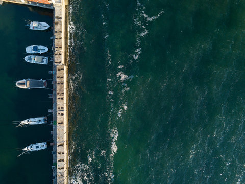 Ship station with powerboars, yachts near concrete dock on a bac