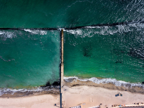 Top aerial view frome drone to seascape with sandy beach breakwa