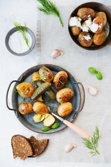 Classic Russian dish baked potatoes with sour cream and herbs and pickles. Vertical photo. Top view