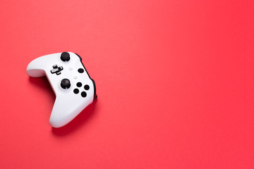 White joystick gamepad, game console isolated on red background. Computer gaming technology play competition videogame control confrontation concept. Cyberspace symbol © Nana_studio