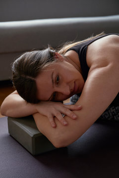 Woman in sportswear sitting on fitness mat