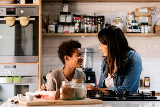 Black boy cooking near happy woman in kitchen