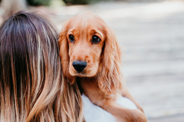 young woman and her cute puppy of cocker spaniel outdoors